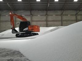 Orange loaders and large white urea fertilizer in the warehouse. photo