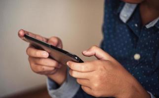 Boy playing games on smartphones, Boy hand holding a smartphone photo