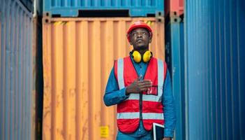 Engineer or supervisor checking and control loading Containers box from Cargo at harbor. Foreman control Industrial Container Cargo freight ship at industry. Transportation and logistic concept. photo