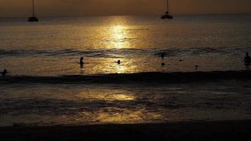 schöner sonnenuntergang mit silhouetten von menschen genießen sie den ozean. video