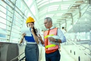 The engineer and business woman checking on clipboard at construction site building. The concept of engineering, construction, city life and future. photo