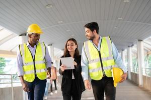 arquitecto, ingeniero civil y trabajador mirando planos y planos, discutiendo problemas en el sitio de construcción foto