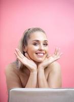 Portrait Of Smiling Young Woman Over Pink  Background photo