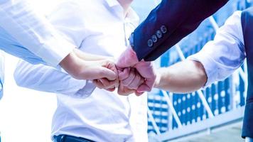 Stack of hands. Unity and teamwork concept. Close up top view of young business people putting their hands together photo