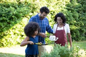 Portrait of happy Mixed race family with little kids preschooler children gardening at home together