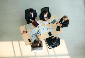 Top view on a group of businessman and businesswoman having a meeting and making a business commitment. photo