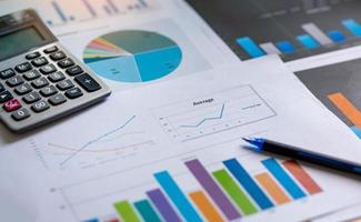 datos de la hoja de análisis financiero con bolígrafo y calculadora. concepto de contabilidad financiera y marketing. foto