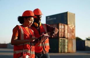 Foreman control loading Containers box from Cargo freight ship for import export. photo
