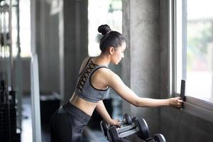 mujer joven haciendo ejercicio en el gimnasio. fuerte atleta femenina haciendo ejercicio. foto