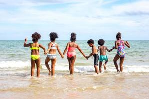 Kids playing running on sand at the beach photo