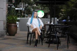 Portrait of Young girl with blue hair, teenage standing on street as urban life. photo