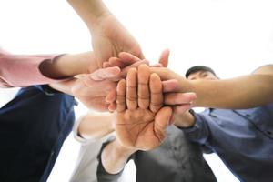 Successful business people standing together widen out showing strong relationship of worker community. A team of businessman and businesswoman expressing a strong group teamwork at the modern office. photo