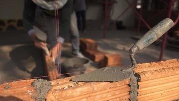 Bricklayer worker installing brick masonry on exterior wall photo