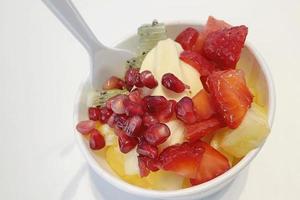 cerrar yogur helado con frutas mixtas en un tazón pequeño