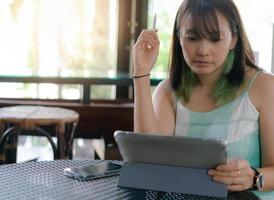 mujer usa tableta para trabajar en línea o trabajar en casa foto