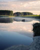 Mist over a pond in summer morning photo