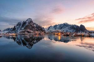 Fishing village with snow mountain at sunrise photo