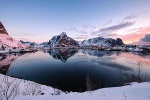 pueblo escandinavo nevado con montaña rodeada en la costa foto