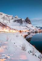 Landscape of road glowing on mountain in norwegian fishing village at arctic coastline photo