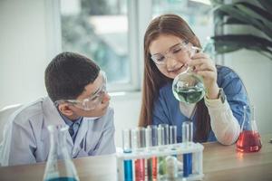 los estudiantes mezclan productos químicos en vasos de precipitados. estudiante de química mezcla productos químicos en la clase de ciencias