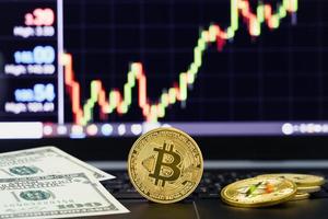 Bitcoin coin on keyboard computer with market price chart background photo