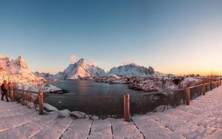 puesta de sol en el pueblo de pescadores con montaña nevada en reine foto