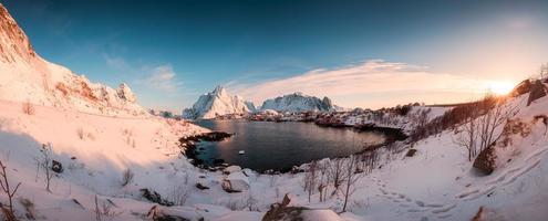 Panorama of fishing village in snow valley at sunrise