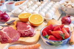 Preparing for cooking at dinner with beef, fruits, vegetables, and flavorings on table photo