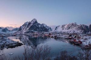 pueblo pesquero con montaña nevada en la costa en invierno foto