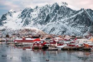 Boat sailing on fishing village in snowy valley photo