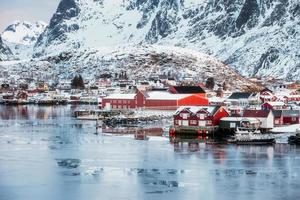 Fishing village of Reine on frosty coastline with snowy mountain photo