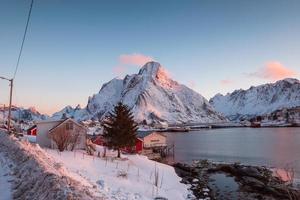 Scenery of Lofoten Islands on winter. Snowy mountain with fishing village on coastline at Norway photo