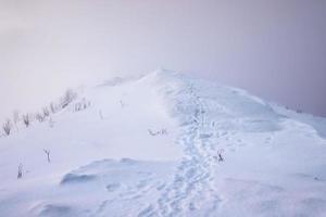 Snowy mountain peak with footprints