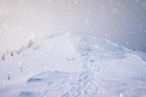 Snowy mountain peak with footprints photo