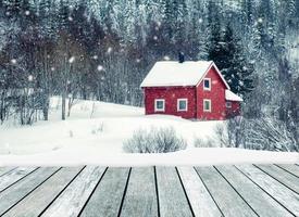 Wooden gray with red house in snowing on winter photo
