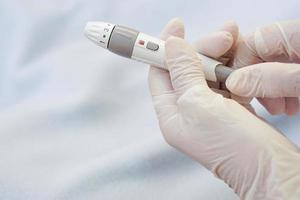 Closeup of doctor hands wear gloves holding syringe for insulin to check blood sugar level by glucose. photo