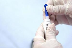 Closeup of doctor hands wear gloves holding syringe for insulin to check blood sugar level by glucose. photo