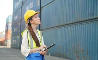 Female Foreman checking containers for ship at terminal port. photo