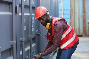 Engineer or supervisor checking and control loading Containers box from Cargo at harbor. Foreman control Industrial Container Cargo freight ship at industry. Transportation and logistic concept. photo