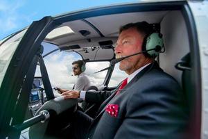 Business people traveling by helicopter , Shot of a mature businessman using a headset while traveling in a helicopter photo