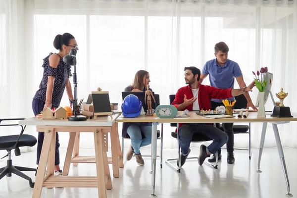 Diverse group of young business people discussing a work project while sitting together at a table in a modern office. coworking concept