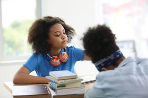 los niños afroamericanos estudian con amigos en clase. foto