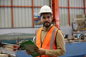 Industry worker Foreman or worker work at factory site check up machine or products in site. Engineer or Technician checking Material or Machine on Plant. Industrial and Factory. photo