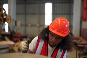 la capataz de la trabajadora o el trabajo del trabajador en el sitio de la fábrica revisan la máquina o los productos en el sitio. ingeniero o técnico revisando material o máquina en planta. industrial y fábrica. foto