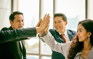 Successful business people standing together widen out showing strong relationship of worker community. A team of businessman and businesswoman expressing a strong group teamwork at the modern office. photo