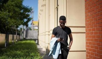 Afro American man having fun walking in city center - Happy young guy enjoying time a sunset outdoor - Millennial generation lifestyle and positive people attitude concept photo