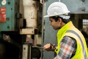 el trabajo de los trabajadores en el sitio de la fábrica revisa la máquina en la línea de productos o los productos en el sitio. ingeniero o técnico revisando material o máquina en planta. industrial y fábrica. foto