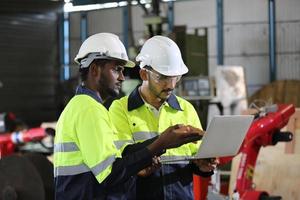 Maintenance Engineers is working in front of the automated CNC machinery repair on a maintenance checklist at the production line. photo
