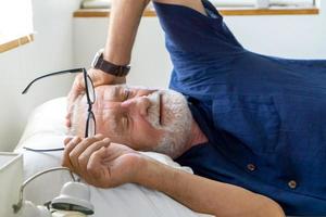 un anciano reintentado con canas duerme en el dormitorio durante el día para relajarse. foto