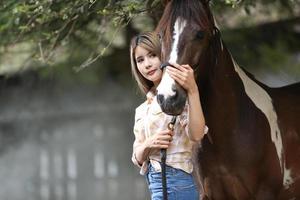 Young woman with her horse in evening sunset light. Outdoor photography with fashion model girl. Lifestyle mood photo